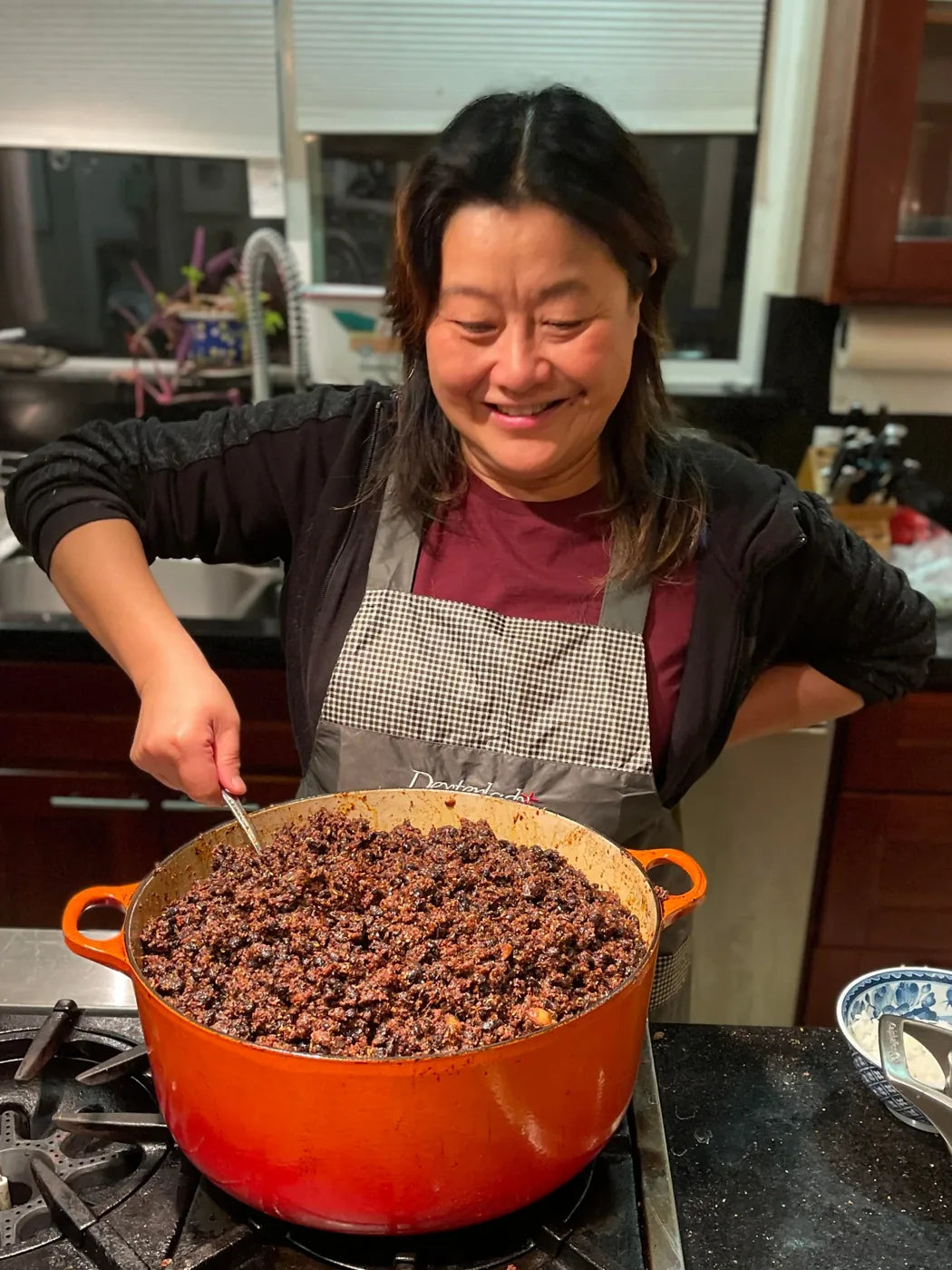 Wei Wei stirring a big pot of Funky Beans in her kitchen